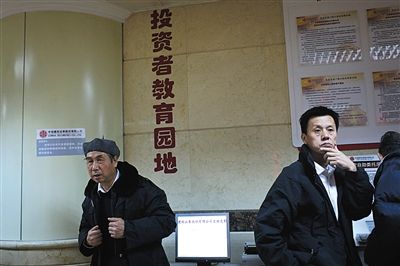12月9日，东直门一家证券营业厅内的一个角落，两位股民专注地紧盯股市大盘。