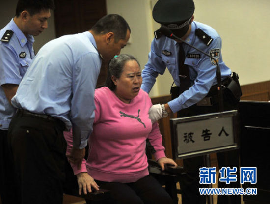 图为9月24日，在公诉人宣读起诉书时，丁书苗身体不停颤抖，一度站立不稳差点摔倒，被法警扶住。(新华社记者公磊摄)